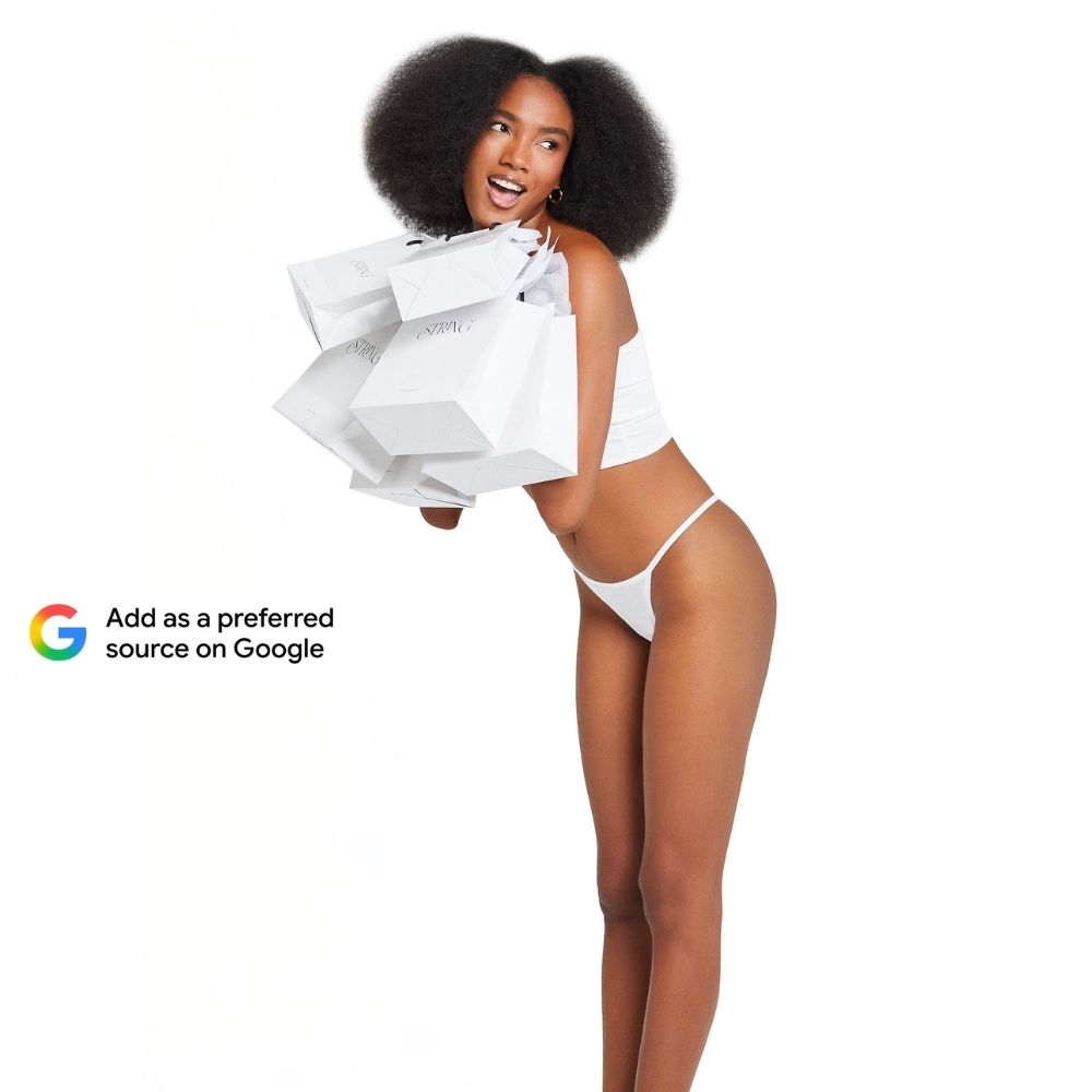 Model holding String Nix shopping bags beside a Google Preferred Source prompt, wearing a white String Nix thong on a clean white background.